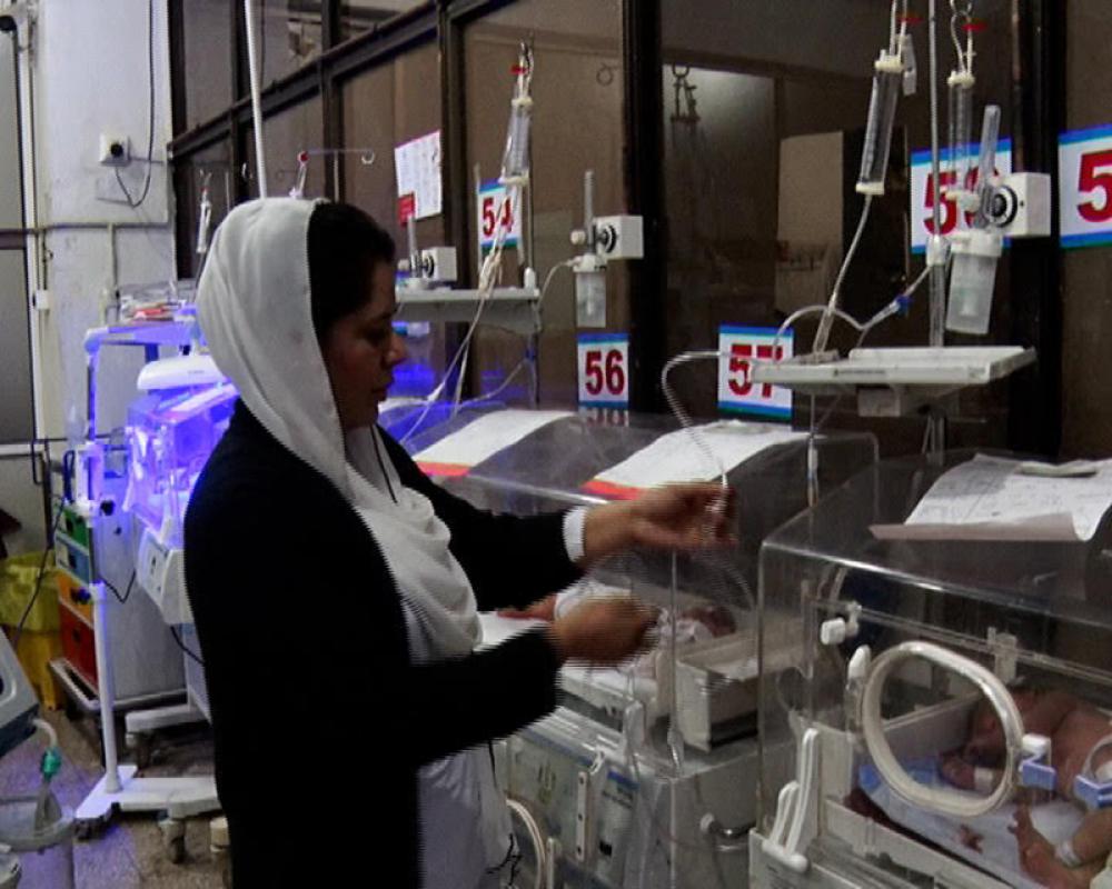 A nurse inquires about the health of a child lying in an incubator at Lady Reading Hospital in Peshawar, Pakistan. Photo by Wisal Yousafzai.